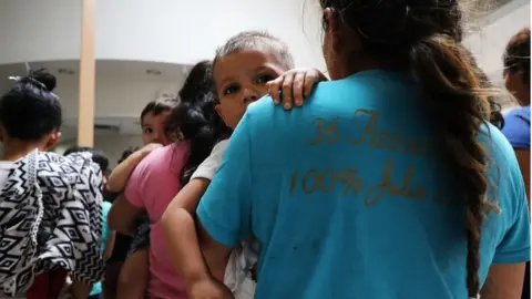 Getty Images Migrant mother holding child