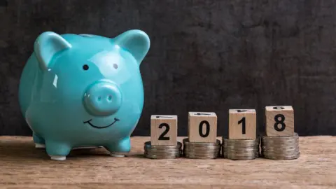 Getty Images Piggy bank with piles of coins