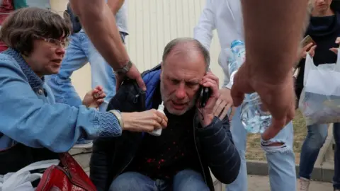 Reuters A man reacts outside a detention centre as paramedics arrive to deliver medical support to his son, who was detained during recent protests against the presidential election results in Minsk, Belarus August 13, 2020