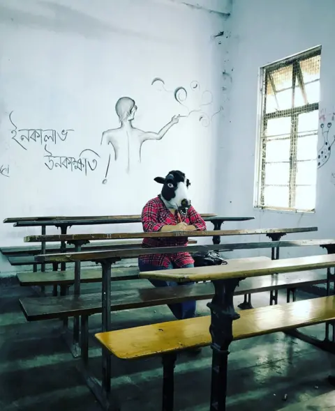 Sujatro Ghosh A woman with a cow mask in a college classroom