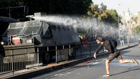 Reuters A demonstrator clashes with riot police during a protest against the increase in the subway ticket prices in Santiago