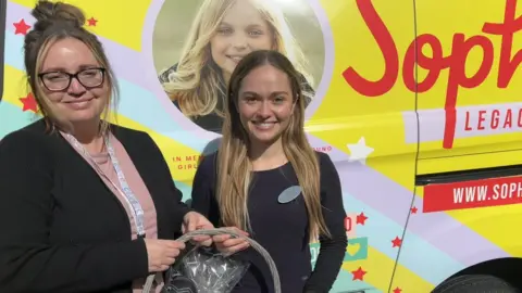 Specsasvers Havant Specsavers audiologist Ruth Avierinos and a representative from Sophie's Legacy