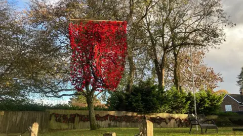 2,000 red poppies hanging in a tree