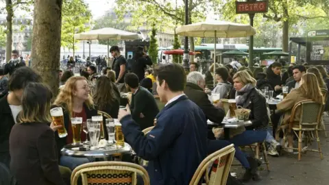 AFP Customers drink beers at outdoor terraces in Paris