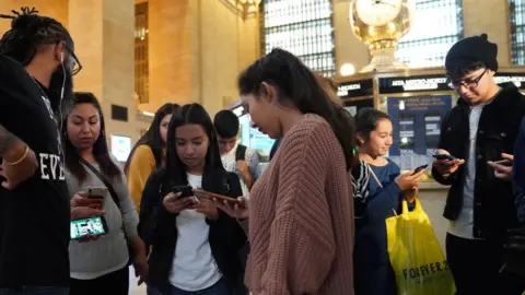 Getty Images People look at their phones during the alert in New York's Grand Central Station