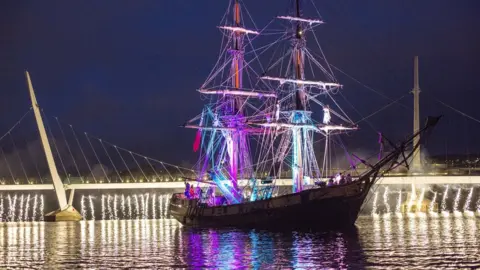 Derry City & Strabane District Council tall ship with peace bridge in background