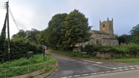 Google Village crossroads with church and trees