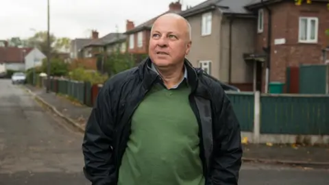 BBC / Jon Parker Lee Eamonn, who still lives in north-west England, revisiting one of his former streets in Manchester