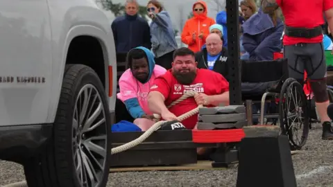 Jakabol Strongfit Dave Walsh pulling a car along at an event