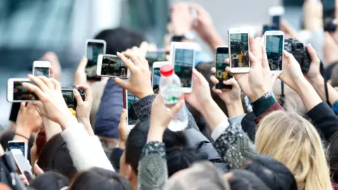 Getty Images People taking pictures on phone