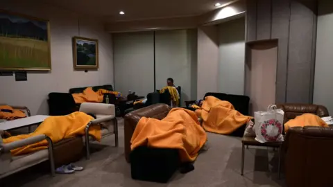 EPA Evacuees sleep on makeshift beds in a shelter after emergency crews evacuated nearby hotel guests, in Sengokuhara, in Nakone province, Japan, 12 October 2019.