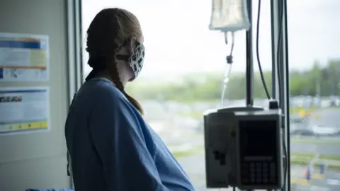 Getty Images stock image of pregnant woman with mask in hospital