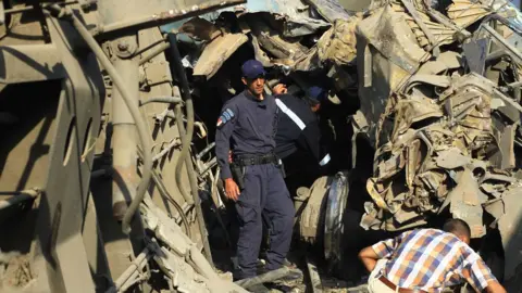 EPA Egyptian security personnel examine wreckage after two passenger trains collided in Alexandria