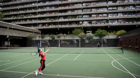 Getty Images Residents in Barbican, London, playing tennis