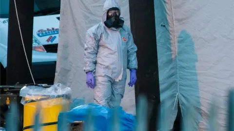 Getty Images A police officer in a forensics suit and protective mask stands by a forensics tent in Salisbury