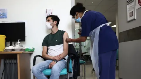 Reuters A young man receiving a vaccine