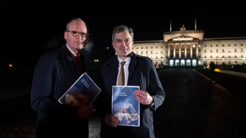 Getty Images Irish Foreign Minister Simon Coveney and Northern Ireland Secretary Julian Smith held a press conference in the dark at Stormont to announce New Decade, New Approach
