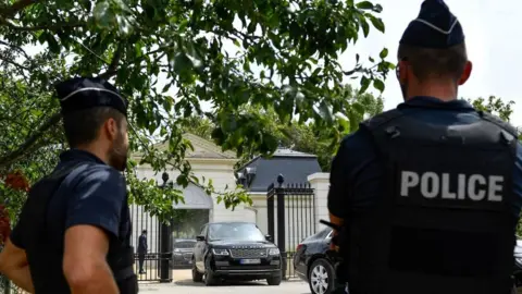 Getty Images Police stand by as a convoy reportedly transporting Saudi Crown Prince Mohammed bin Salman leaves the gated entrance of the Chateau Louis XIV, in Louveciennes