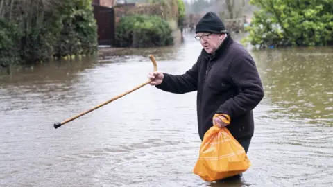 PA Media Man walks through flood water near his home in Tadcaster after the River Wharfe