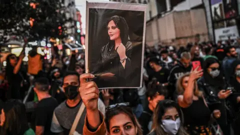 Getty Images A protester holds a portrait of Mahsa Amini during a demonstration in Istanbul on 20 September 2022