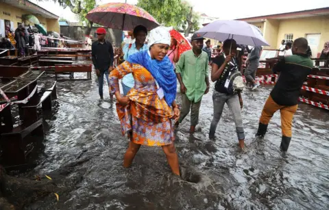 Reuters Voters wade through flood water at a polling station during the presidential election in Kinshasa, Democratic Republic of Congo, December 30, 2018