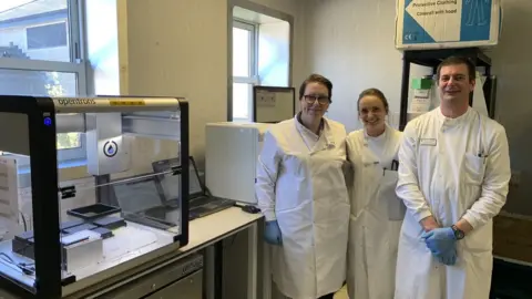 IOM Government Microbiologists with lab equipment