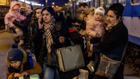 Getty Images People arrive to the Western Railway Station from Zahony after crossing the border at Zahony-Csap as they flee Ukraine