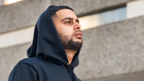 Premz Premz looking in the distance wearing a hoodie