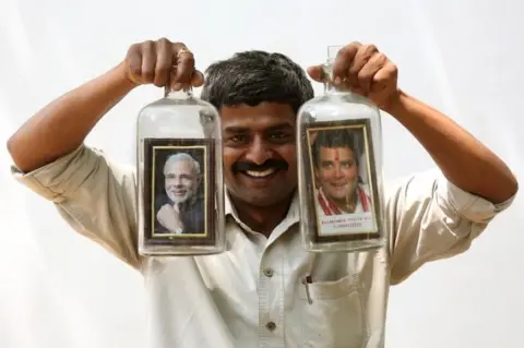 EPA Indian bottle artist Basavaraj displays bottles designed with photos of Indian Prime Minister Narendra Modi and President of the Indian National Congress Rahul Gandhi during general elections in Bangalore, India, 12 April 2019