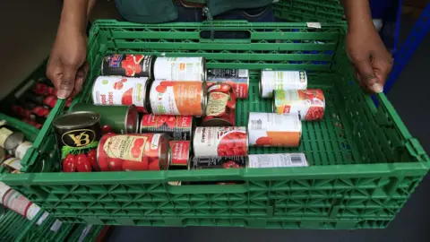 Jonathan Brady/PA Tinned tomatoes at food bank