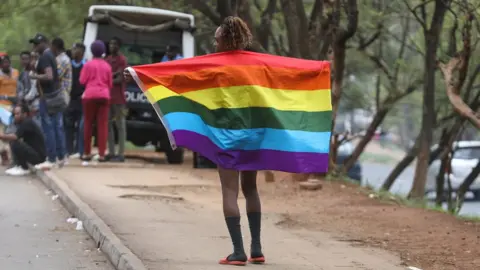EPA A member of Refugee Flag Kenya, an organisation that protects LGBT refugees and asylum seekers in Kenya poses for a photo during a demonstration outside the United Nations High Commissioner for Refugees (UNHCR), offices in Nairobi, Kenya, 13 May 2019.