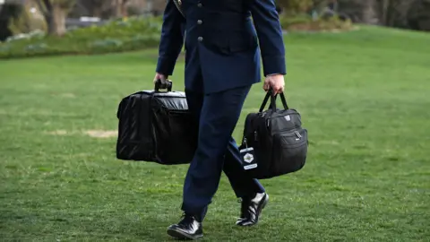 Getty Images A military aide carries the presidents nuclear football