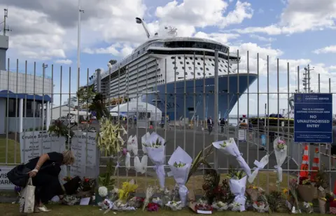 Getty Images People leave tributes at the Port of Tauranga