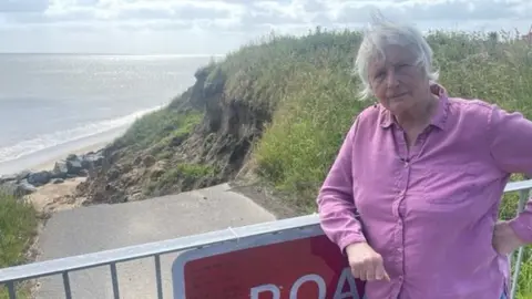 Jonah Fisher woman standing beside road closed sign