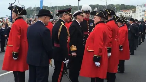 Men dressed in military outfits stand on street