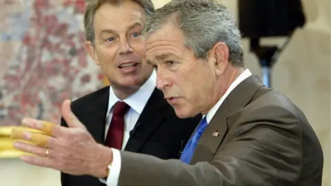 Getty Images President Bush shows his injured hand after a bike accident during the G8 summit at Gleneagles in July 2005