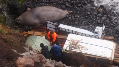 Kimberley Collins Project workers bringing a water tank ashore at Antipodes Island