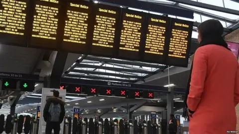 PA Media Passenger looking at a departure board