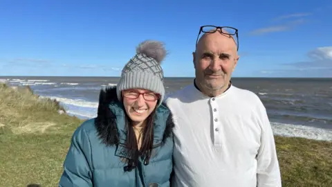 Martin Barber/BBC Mary and Pat Whitey stand on the cliffs at Hemsby beach