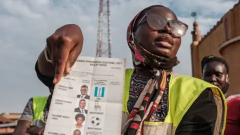 AFP Woman holding up a ballot paper