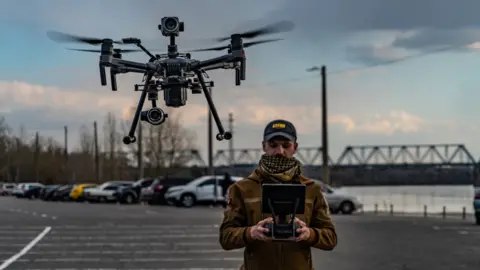 Ruslan Beliaiev a man flying a drone