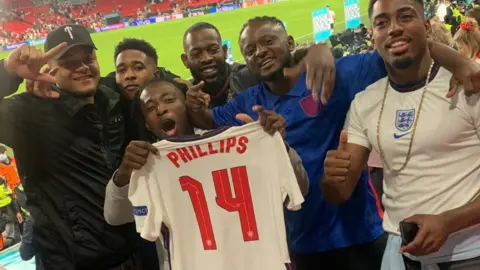 Micaiah Williams Friends of Kalvin Phillips holding his England shirt after 2-1 win over Denmark