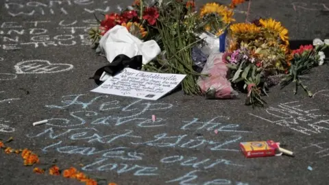 Reuters Flowers lie at a makeshift memorial a day after a car hit counter-protesters in Charlottesville, Virginia, 13 August 2017.