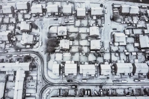 PA Media Aerial view of snow covered houses and streets