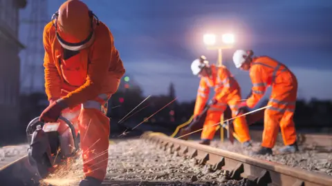 Getty Images People working on rail tracks