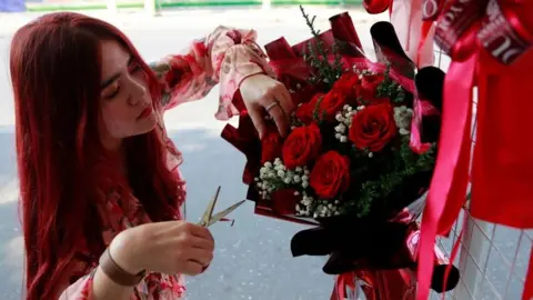 A woman prepares flowers to be sold on Valentine's Day in Cambodia