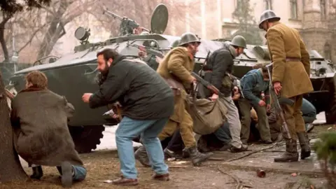 Getty Images Romanian troops and civilians hide from snipers in downtown Bucharest - 24 December 1989