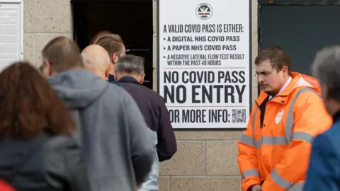 Getty Images Covid pass warning at football match