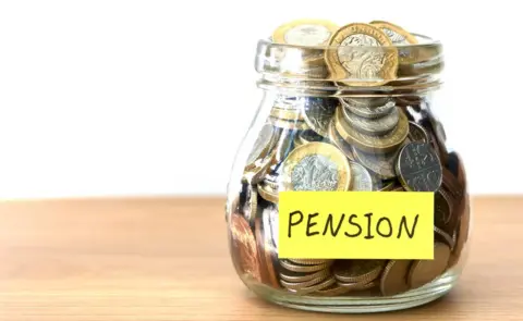 Getty Images Money in a jar marked "pension"