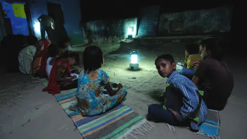 Getty Images Children studying by solar light at a night school in Ajmer, Rajasthan